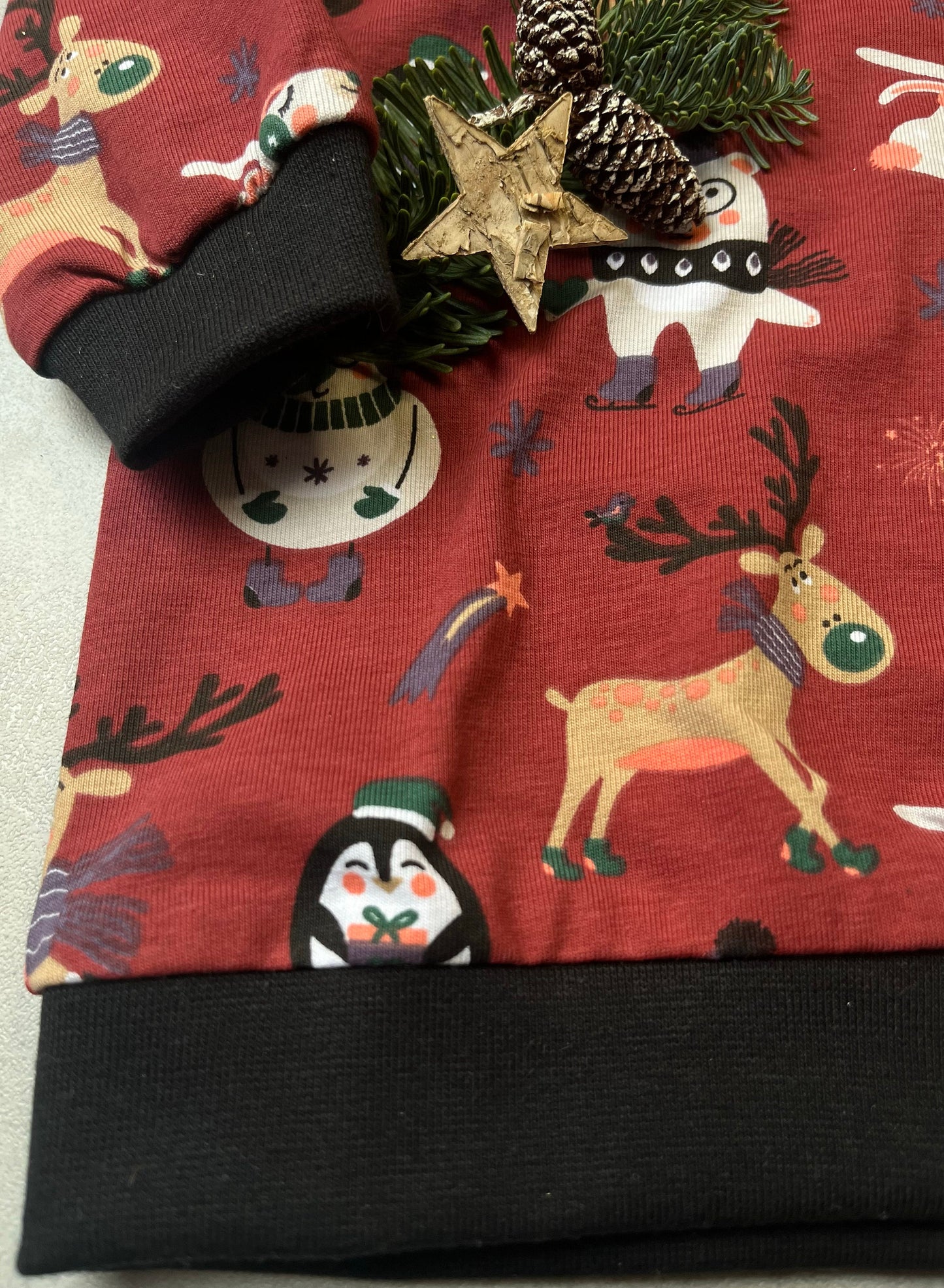 Handgemachter Kinder Weihnachts-Hoodie – Detailansicht Saum & Bündchen mit schwarzem Bündchen und Weihnachtstieren-Motiv