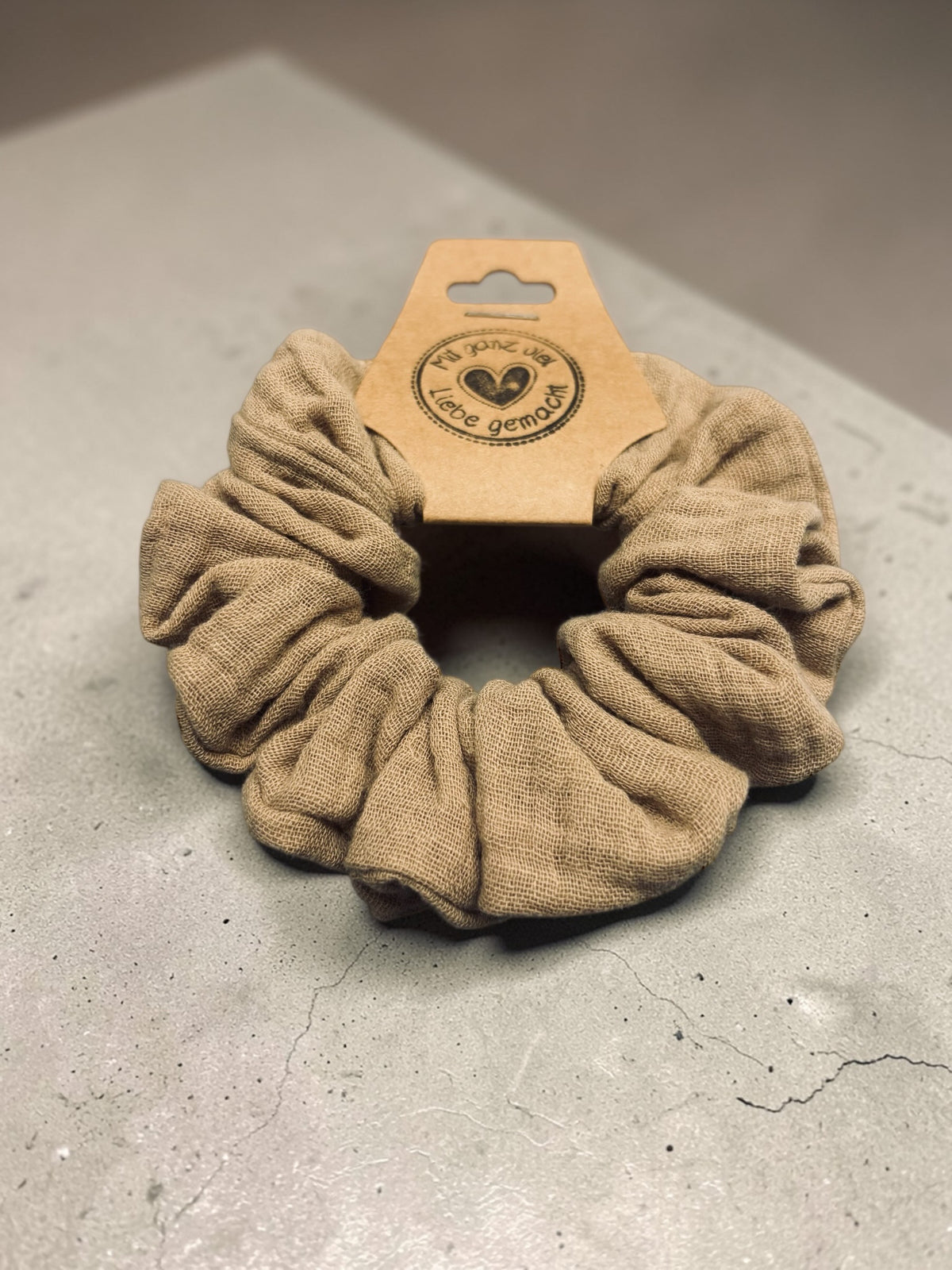 Großer handgemachter Musselin-Scrunchie in Farbe Leinen, aus schräger Perspektive mit sichtbarer Stoffstruktur
