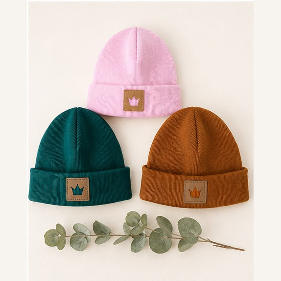 Drei handgemachte Hipster Beanie Mützen liegend – Rosa (oben), Tannengrün (links), Rostbraun (rechts) mit Kronen-Label | OhMamaLina