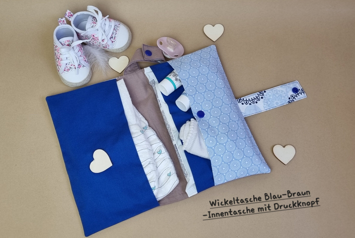 Handgemachte Windeltasche Weiß-Blau & Braun – geöffnet mit Fächern und Beispielbefüllung (wird ohne Inhalt verkauft), Flatlay