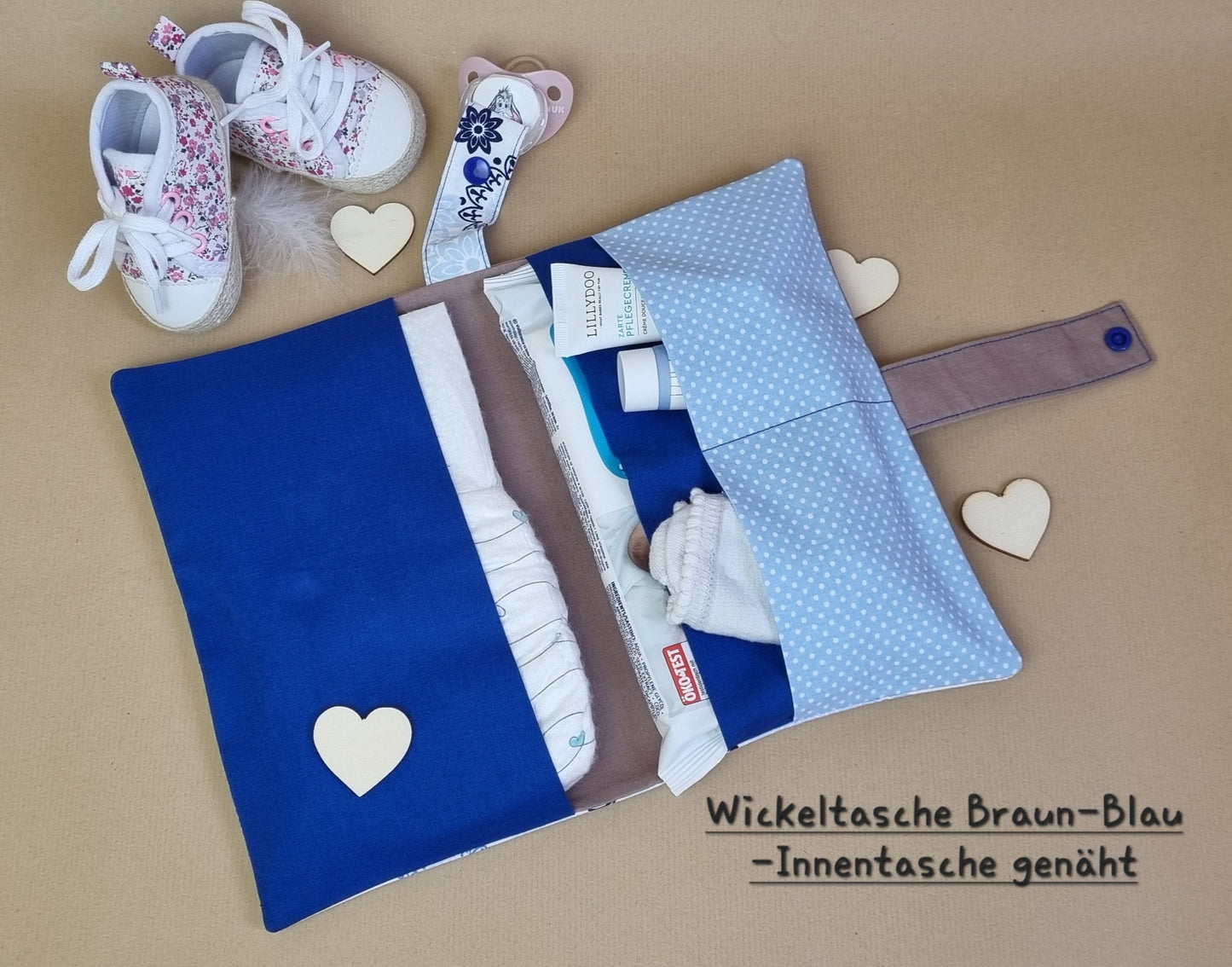 Handgemachte Windeltasche Braun & Weiß-Blau – geöffnet mit Fächern und Beispielbefüllung (wird ohne Inhalt verkauft), Flatlay