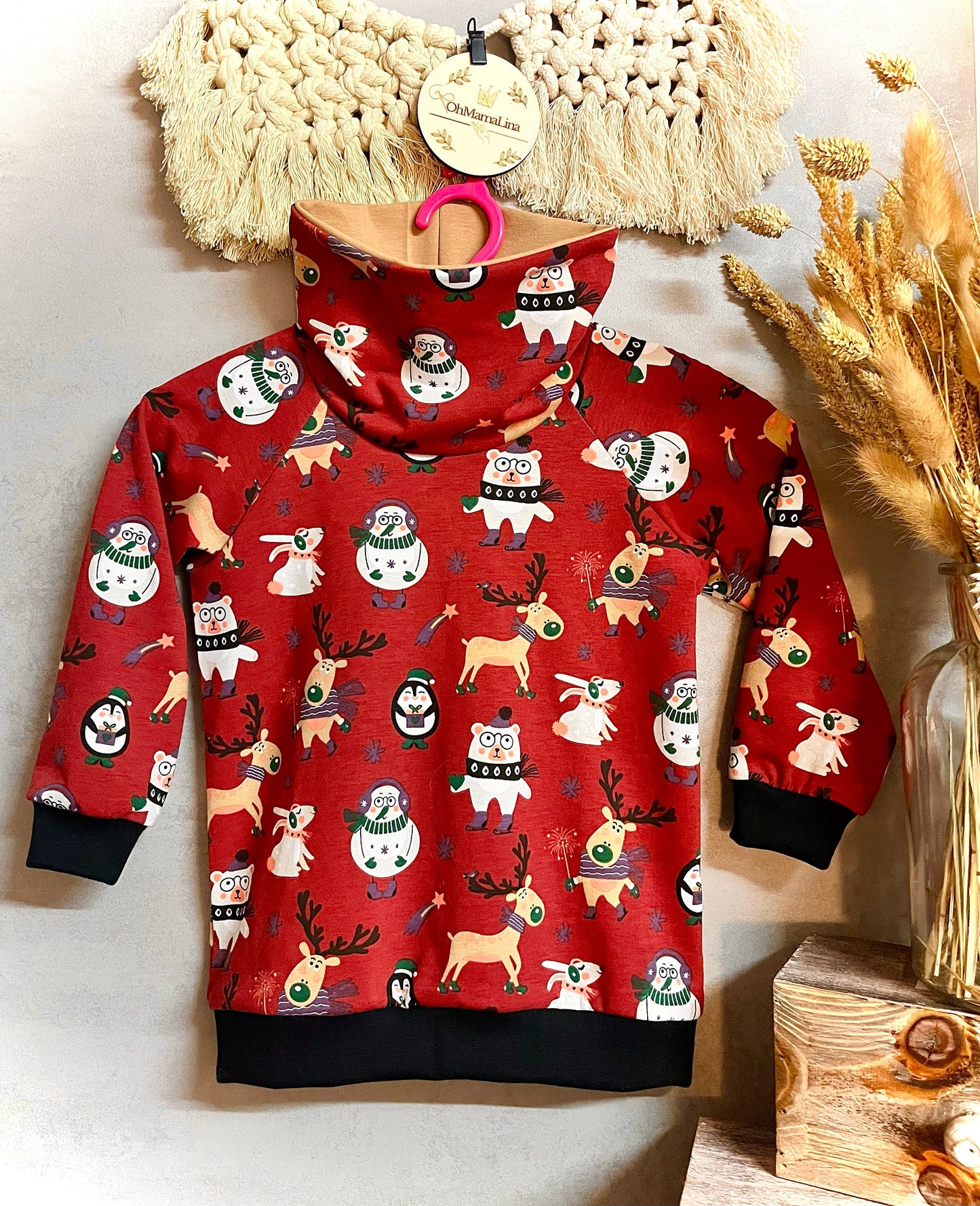 Handgemachter Kinder Weihnachts-Hoodie in Rot mit Weihnachtstieren-Motiv – Vorderansicht auf Bügel, beide Ärmel zur Seite
