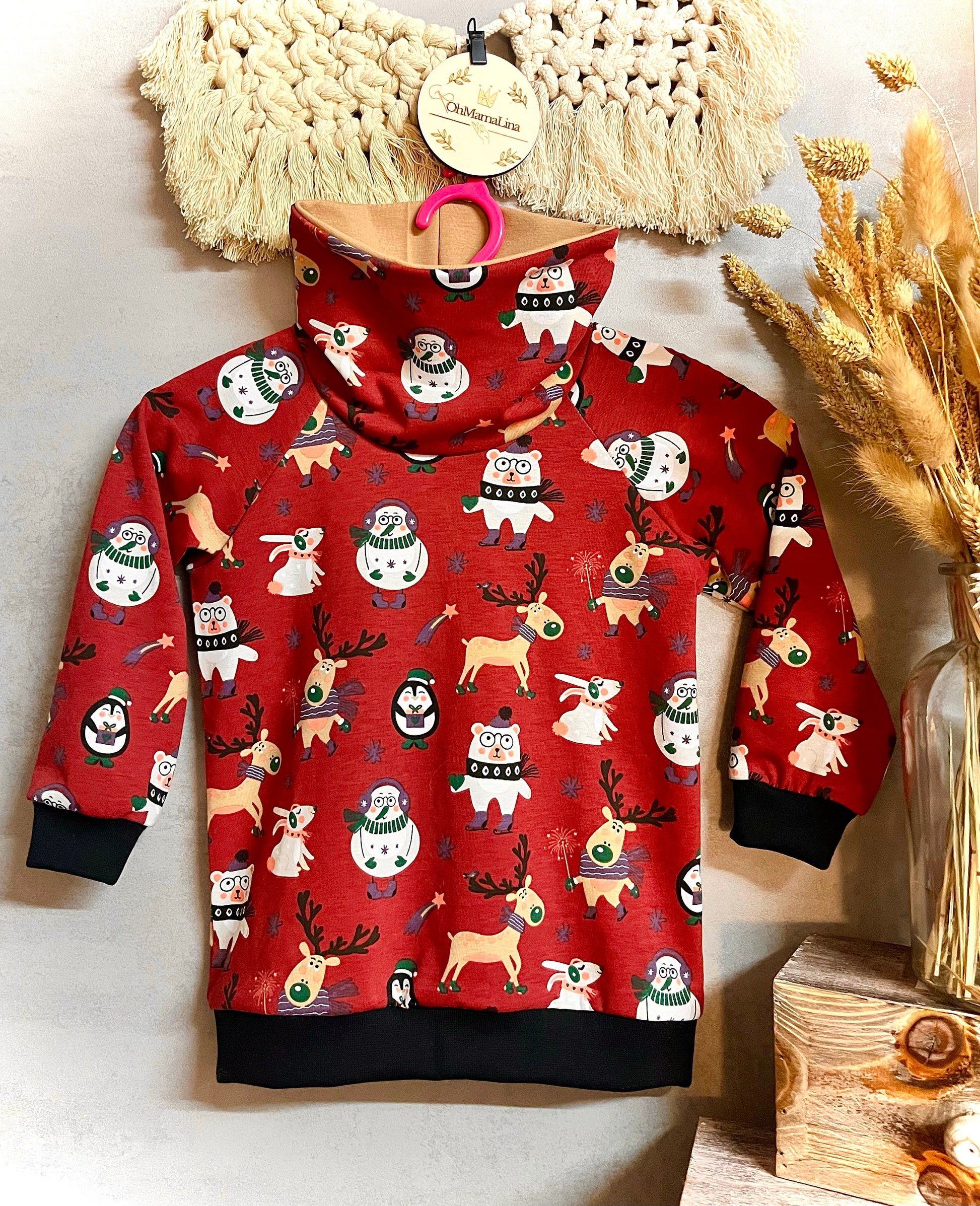 Handgemachter Kinder Weihnachts-Hoodie in Rot mit Weihnachtstieren-Motiv – Vorderansicht auf Bügel, beide Ärmel zur Seite