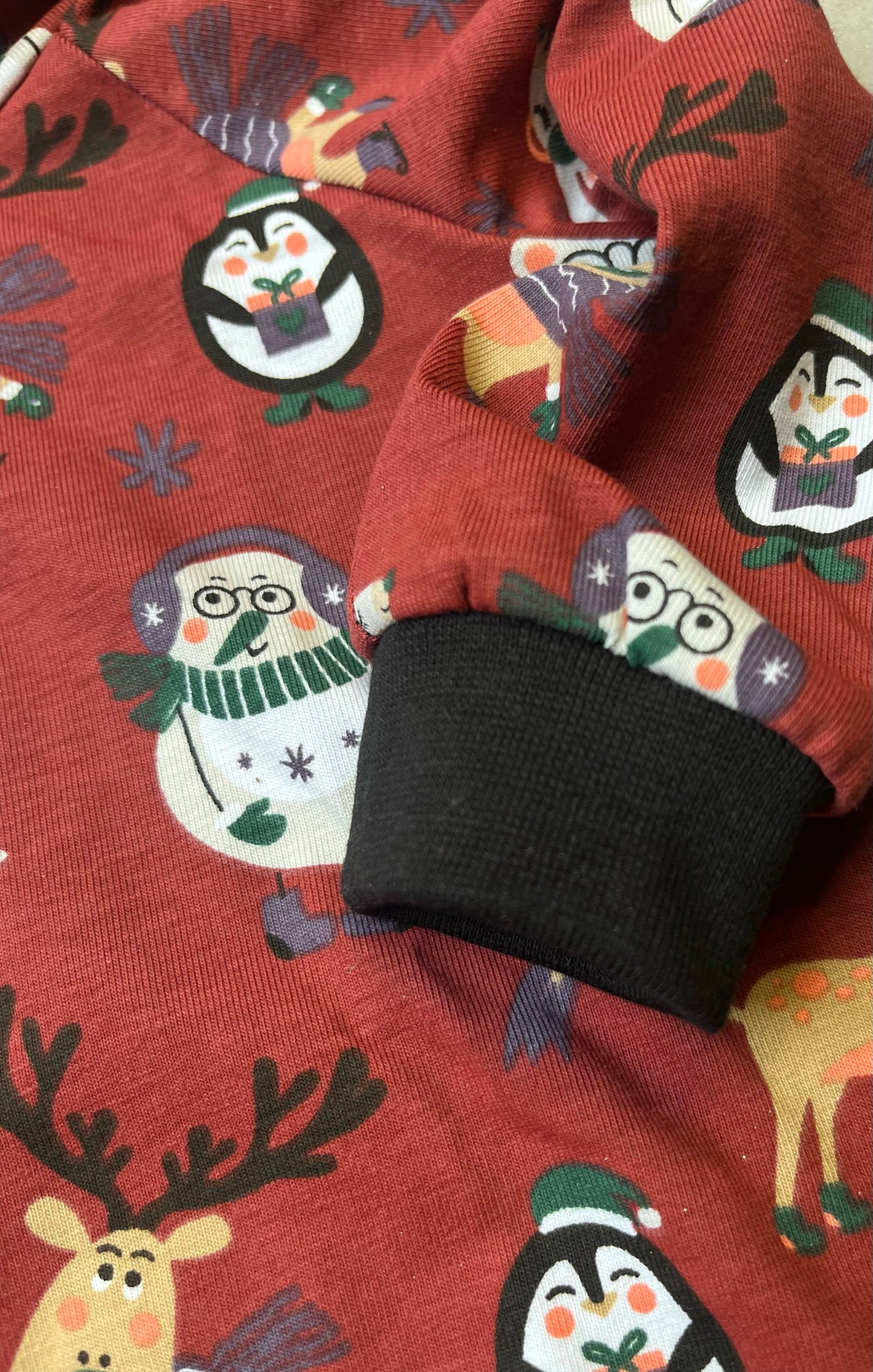 Handgemachter Kinder Weihnachts-Hoodie – Detailansicht Ärmel mit schwarzem Bündchen und Weihnachtstieren-Motiv