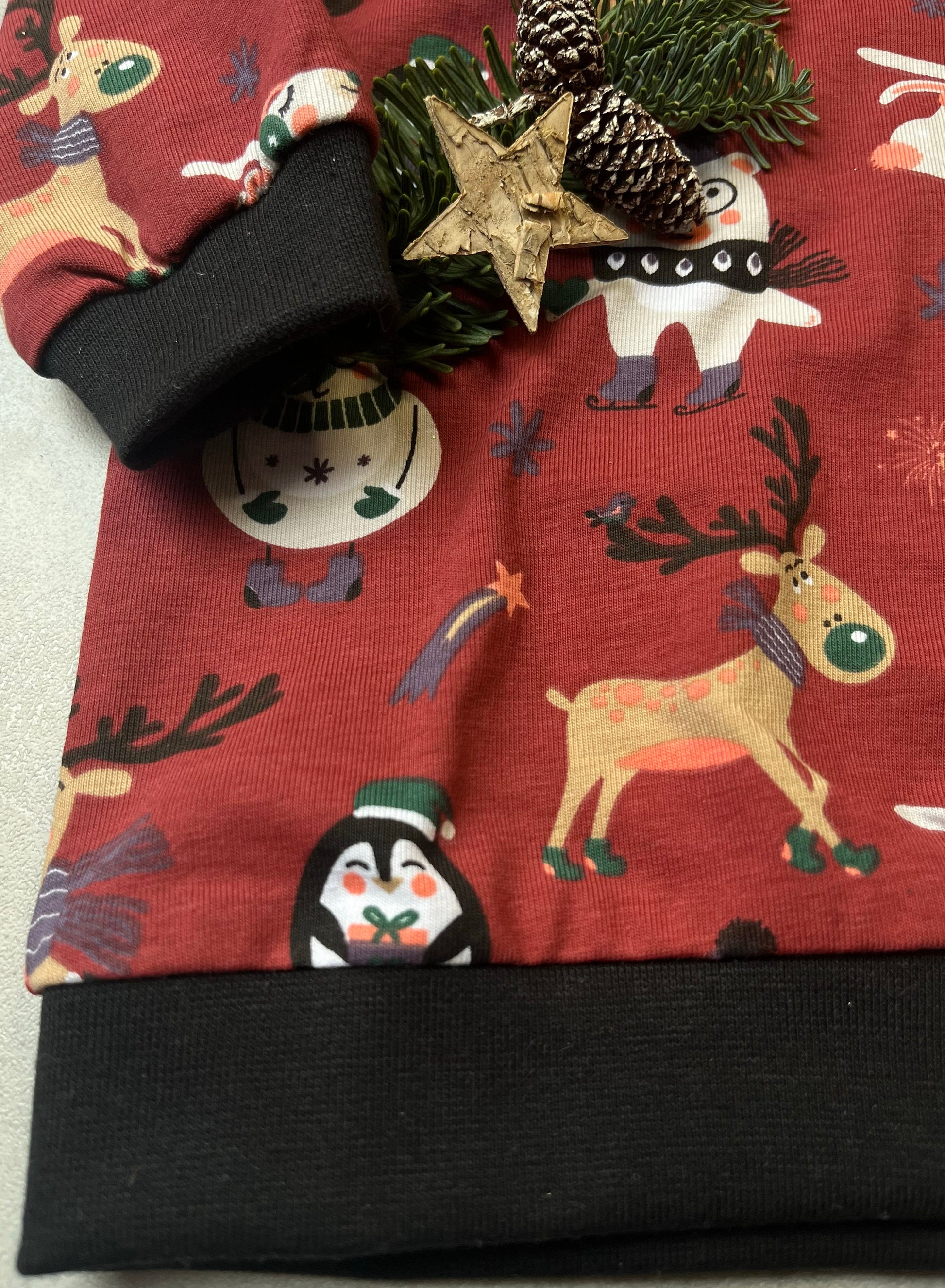 Handgemachter Kinder Weihnachts-Hoodie – Detailansicht Saum & Bündchen mit schwarzem Bündchen und Weihnachtstieren-Motiv