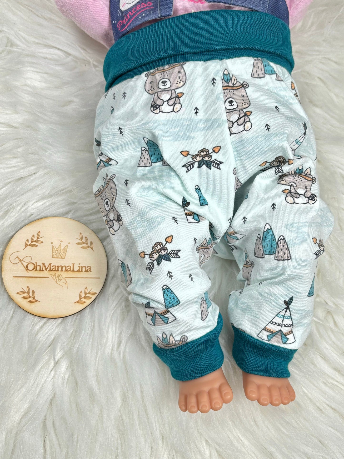 Handgemachte Baby Leggings mit Indianer-Bär-Motiv – an Baby-Puppe, Vorderansicht