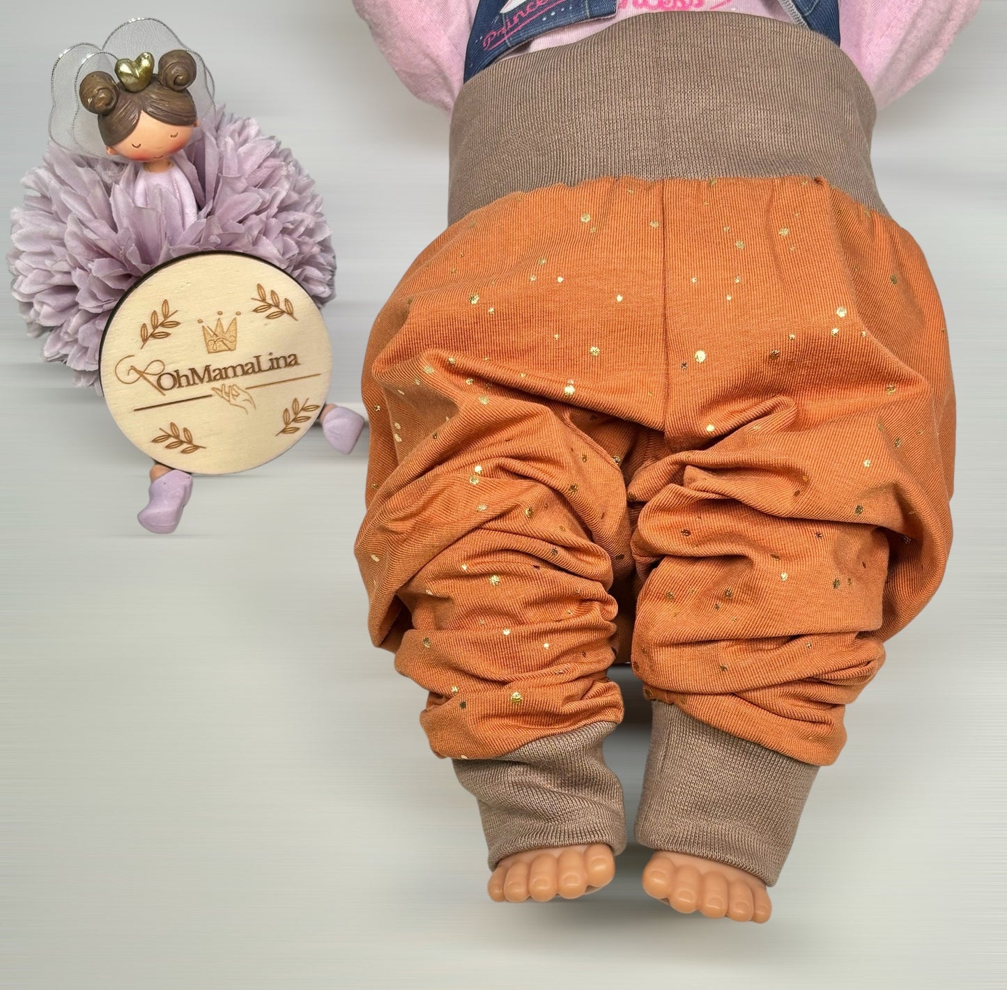 Handgemachte Baby Leggings in Rost mit goldenen Folien-Tupfen und taupefarbenem Bündchen – Vorderansicht an Baby