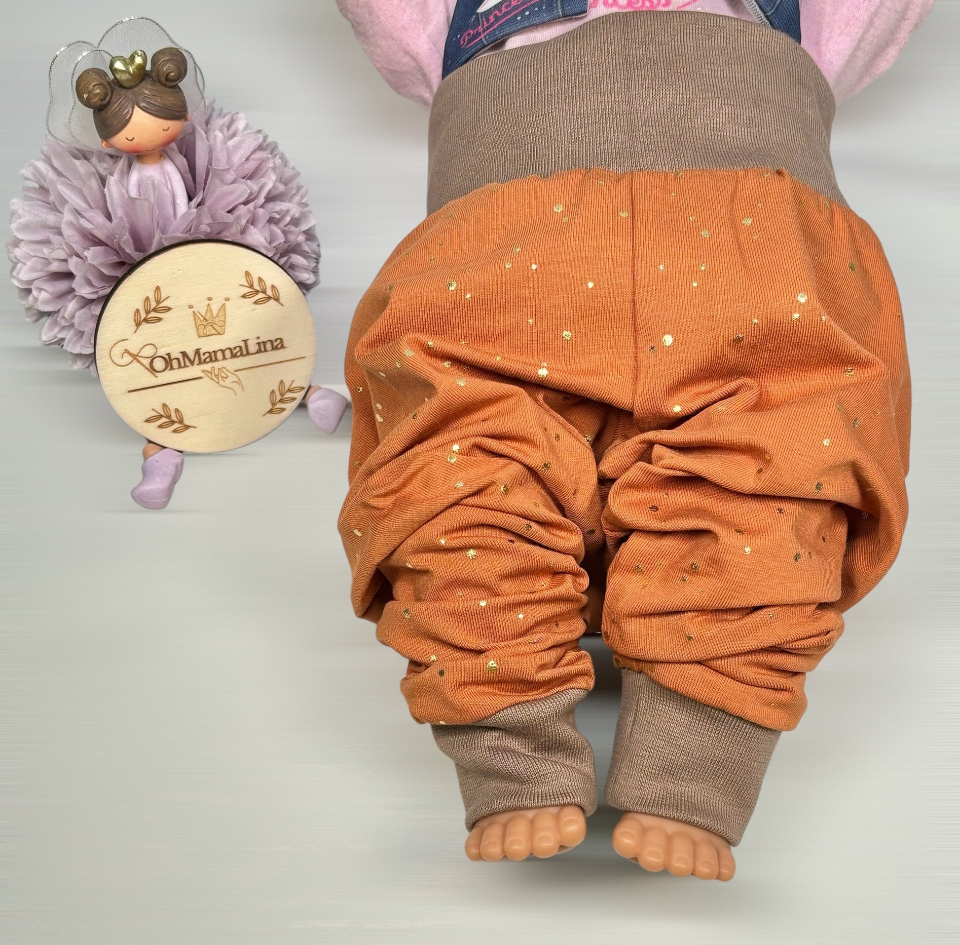 Handgemachte Baby Leggings in Rost mit goldenen Folien-Tupfen und taupefarbenem Bündchen – Vorderansicht an Baby