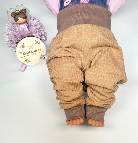 Handgemachte Baby Leggings in Karamell aus Waffeljersey mit braunem Bündchen – Vorderansicht an Baby